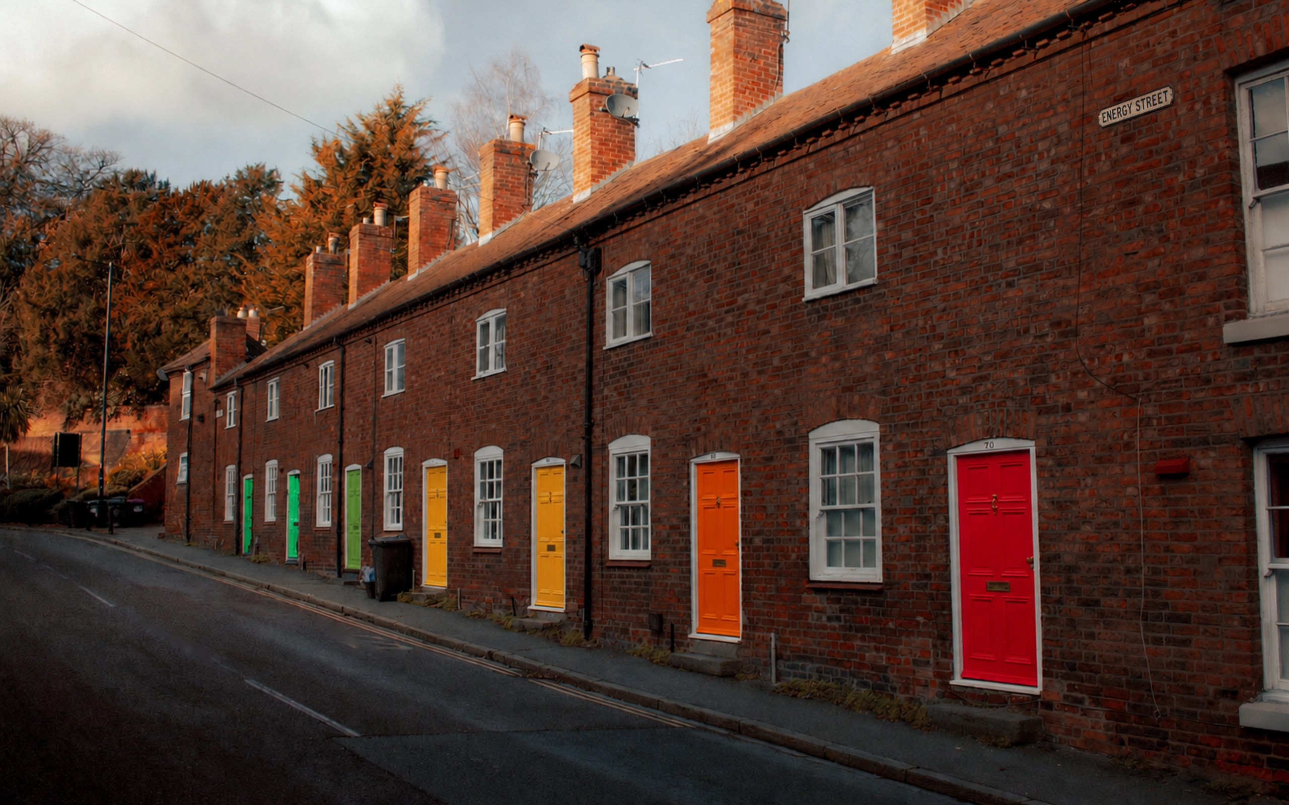 Terrace of red-brick rented houses with brightly painted front doors